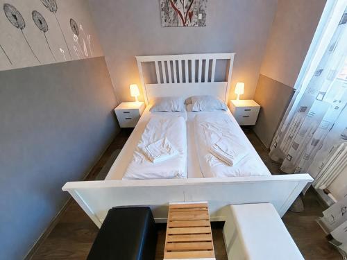 a bedroom with a large white bed with two lamps at Studio Martina mit Pool und Sauna in Freyung