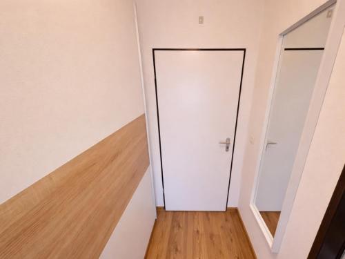 an empty room with a white door and a wooden floor at Studio Sebastian mit Pool und Sauna in Freyung