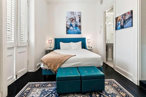 a bedroom with a bed with a blue foot stool at Roami at St. Helene in New Orleans