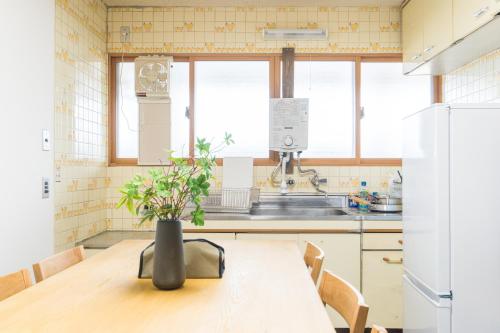 a kitchen with a wooden table with a vase on it at オオジンマチ ハイツ302 in Takayama