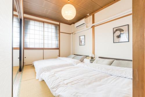 two beds in a room with windows at オオジンマチ ハイツ302 in Takayama