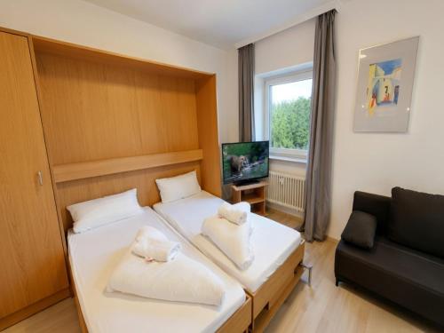 a small bedroom with two beds and a couch at Studio Roswitha mit Pool und Sauna in Freyung
