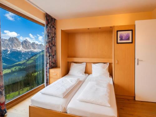 two beds in a room with a large window at Studio Sebastian mit Pool und Sauna in Freyung