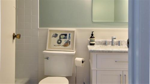 a bathroom with a toilet and a sink at Songbird Sojourn in Cape May Point