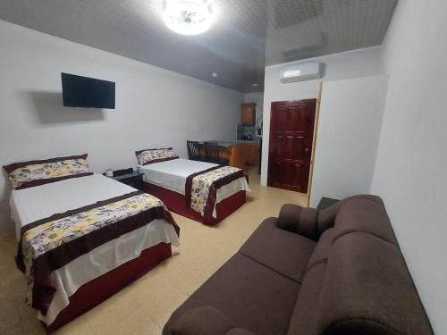 a living room with two beds and a couch at Sotera's Guest House in Corozal