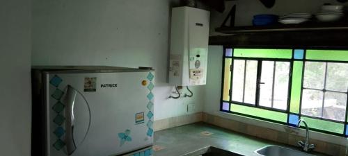 a kitchen with a sink and a washing machine at Casita Naranja in La Calera