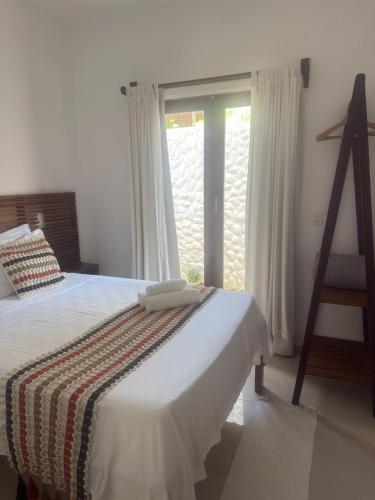 a bedroom with a bed and a large window at Apê Charm Jeri in Jericoacoara