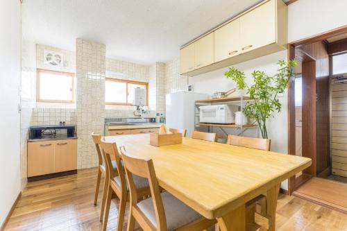 a kitchen with a wooden table and chairs at オオジンマチ ハイツ303 in Takayama