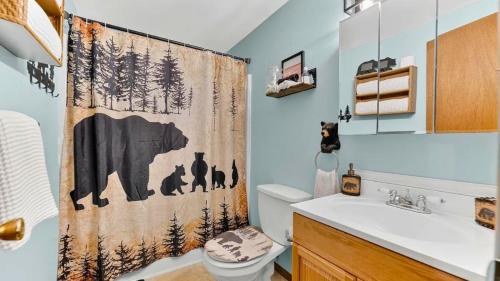 a bathroom with a shower curtain with animals on it at Bear Cabin Hideout in Hamlin