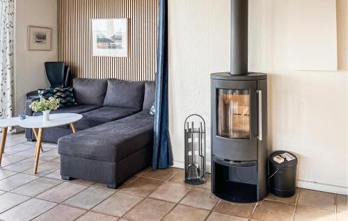 a living room with a couch and a wood stove at Holiday Home Hvedemarken Sjølund Xii in Sjølund