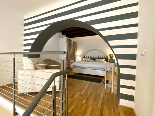 a bedroom with a bed in a room with a striped wall at Loft Nineteen Apartment in La Spezia