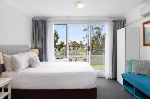 a bedroom with a bed and a large window at Horizons Lake Jindabyne in Jindabyne