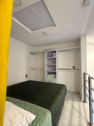 a bedroom with a green bed in a room at Urban Loft Hotel Federalismo in Guadalajara