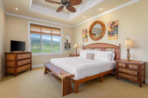 a bedroom with a bed and a tv and a window at Beautiful Ocean Villa in Kawela