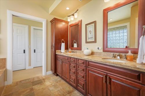 a bathroom with two sinks and a large mirror at Beautiful Ocean Villa in Kawela