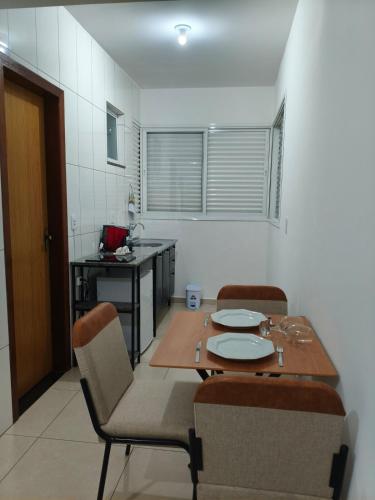a kitchen with a table and chairs in a room at 950 metros da UFV apartamento e ao lado da prefeitura in Viçosa
