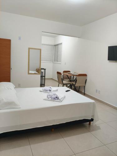 a bedroom with a bed and a table and chairs at 950 metros da UFV apartamento e ao lado da prefeitura in Viçosa