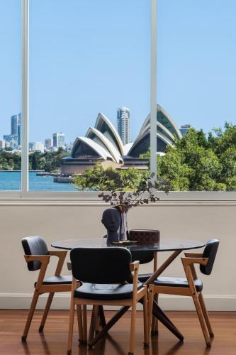 a table and chairs with a view of the sydney opera house at Opera House Retreat - Opera House & Bridge View in Sydney