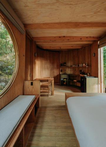 a room with wooden walls and a large window at WANDER Cabins Villa Alpina in Villa Alpina