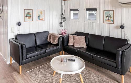 a black leather couch and a table in a living room at Holiday Home Bygmarken Sjølund Xii in Sjølund