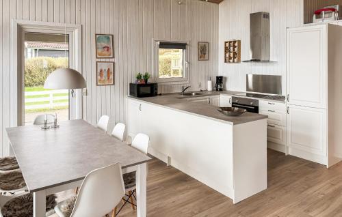 a kitchen with a large white counter top and a table at Holiday Home Bygmarken Sjølund Xii in Sjølund