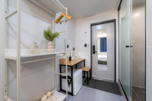 a bathroom with a shower and a sink and a desk at Dongdaemun Stay Garden in Seoul