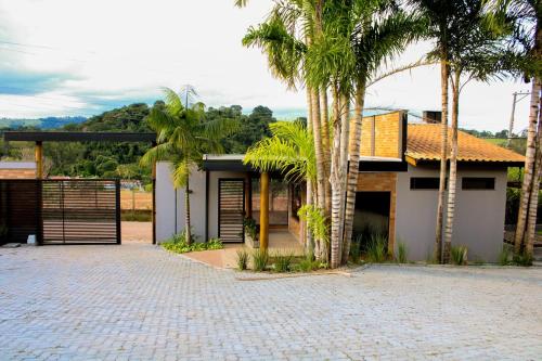 a house with palm trees in front of a driveway at Pousada Villorba in Socorro