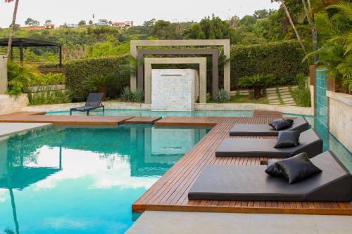 a pool with chaise lounges on a wooden deck at Pousada Villorba in Socorro