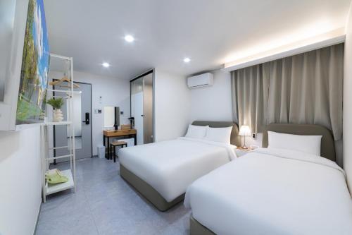 a hotel room with two beds and a desk at Dongdaemun Stay Garden in Seoul