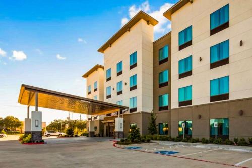 a hotel with a large building with a parking lot at Comfort Inn & Suites Houston I-45 North - IAH in Houston