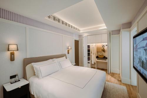 a bedroom with a white bed and a television at METT Singapore in Singapore