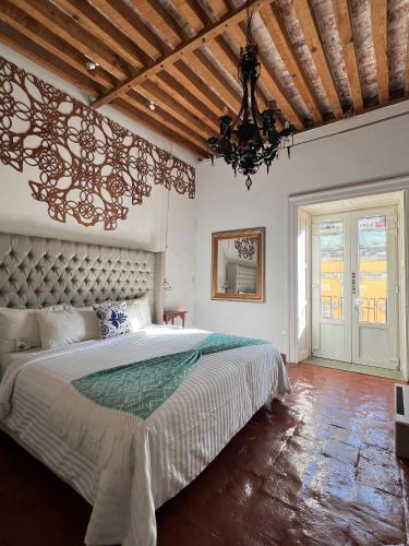 a bedroom with a large bed and a chandelier at Mansion Von Humboldt in Guanajuato