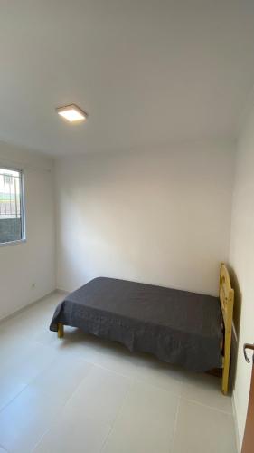 a bedroom with a bed in the corner of a room at Comfortable, well-located, renovated apartment in São Leopoldo