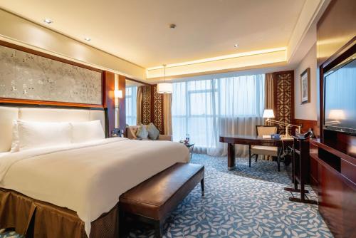 a hotel room with a bed and a desk and a television at C&D Hotel Quanzhou in Quanzhou