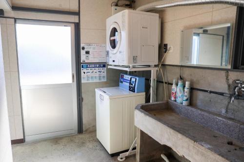 a kitchen with a sink and a washing machine at Udo Torii Gate Stay Yoi in Nichinan