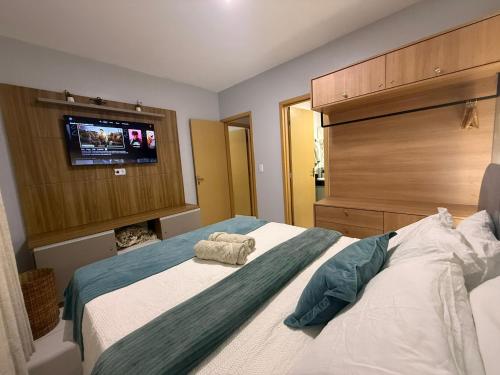 a bedroom with a bed with a flat screen tv at Lençois Confort in Barreirinhas
