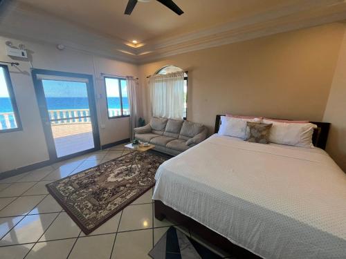 a bedroom with a bed and a couch at Casaroyal Beachfront Siquijor in Siquijor