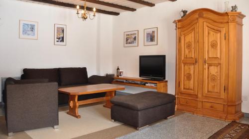 a living room with a couch and a tv at Chalet Goldblick in Grächen