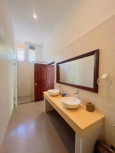 a bathroom with two sinks and a mirror on the wall at Terrace Resort in Phú Quốc