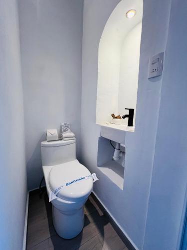 a bathroom with a white toilet and a sink at Mansion Von Humboldt in Guanajuato