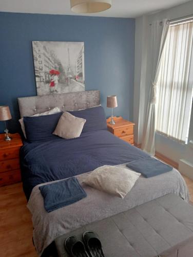 a bedroom with a blue bed with shoes on it at Mountjoy House in Derry Londonderry