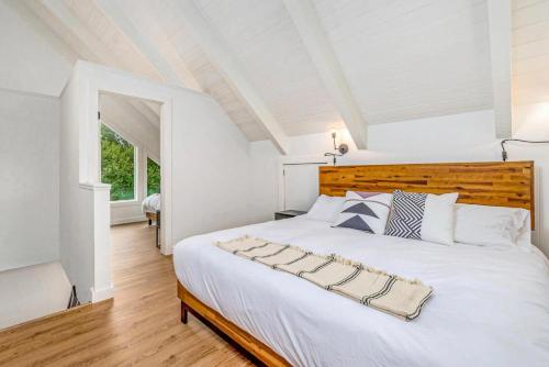 a bedroom with a large white bed with a wooden headboard at Tidal House #6 - Ocean Shores Chalet in Ocean Shores
