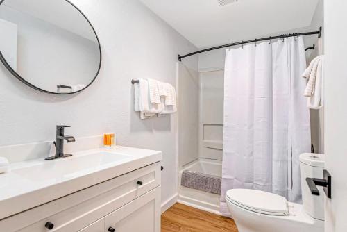 a bathroom with a sink and a toilet and a mirror at Tidal House #6 - Ocean Shores Chalet in Ocean Shores