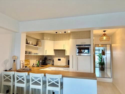 a kitchen with white cabinets and a table and chairs at BEACH apartment met directe toegang tot het STRAND ! in Knokke-Heist