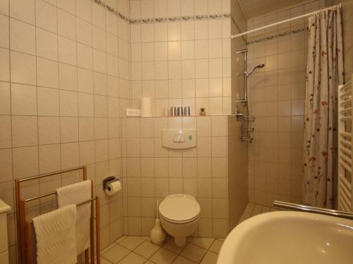 a bathroom with a toilet and a shower and a sink at Reihenhäuser in Strackholt in Strackholt