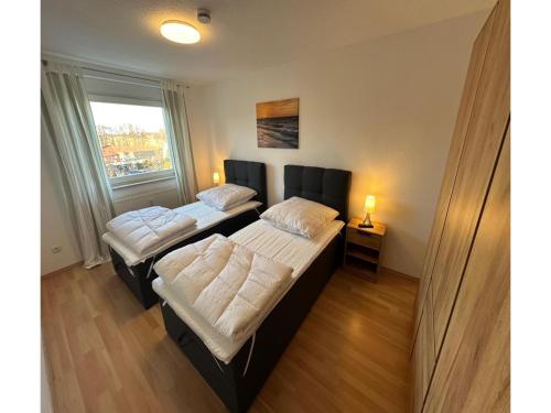 two beds in a room with a window at behagliche Ferienwohnung in Elstra in Elstra