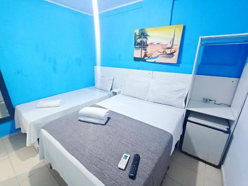 two beds in a small room with blue walls at Pousada Sol e Mar de Pajuçara in Maceió