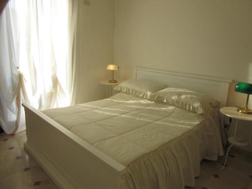 un letto bianco in una camera da letto con finestra di Zara Apartment a Treviso
