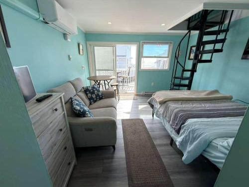 a room with a bed and a couch and a staircase at Oceanview Loft York in York