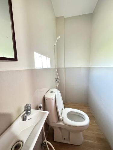 a bathroom with a white toilet and a sink at Southsea Staycation-couple in Nasugbu